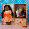 Doll with an orange dress in a box with wardrobe accessories 